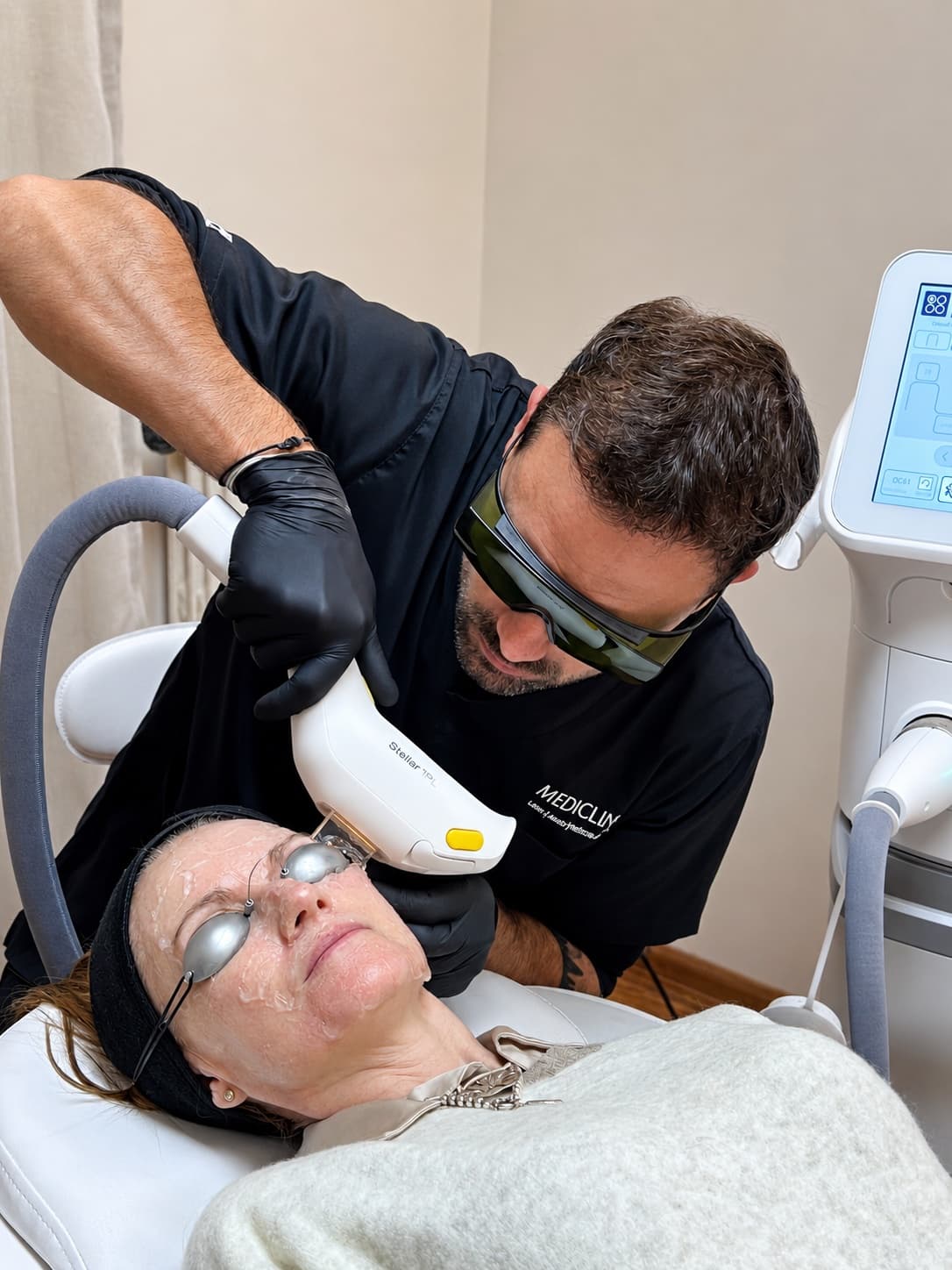Médico aplicando luz pulsada intensa sobre una paciente con protección ocular